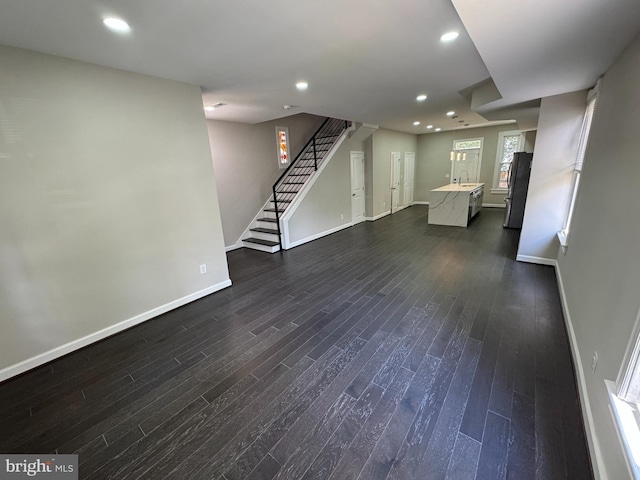 unfurnished living room featuring dark hardwood / wood-style flooring and sink