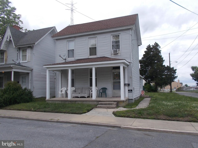 view of front of property with covered porch and a front yard