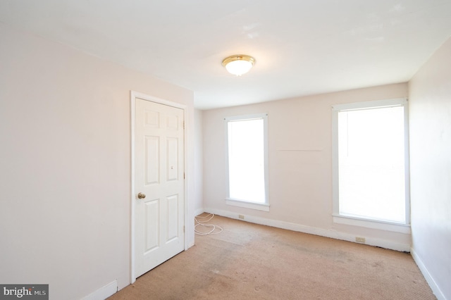 unfurnished room featuring light carpet