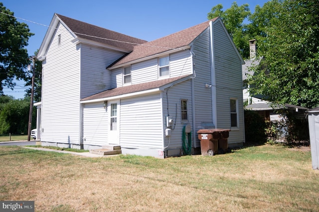 rear view of house featuring a lawn