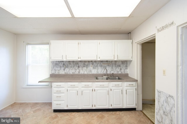 kitchen featuring white cabinets, a paneled ceiling, and sink