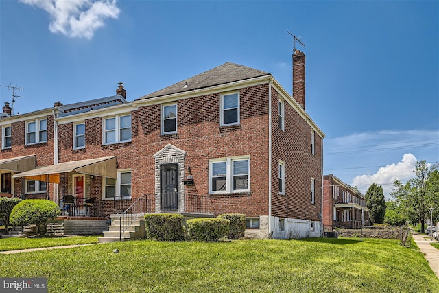 view of front of property featuring a front yard and central AC unit