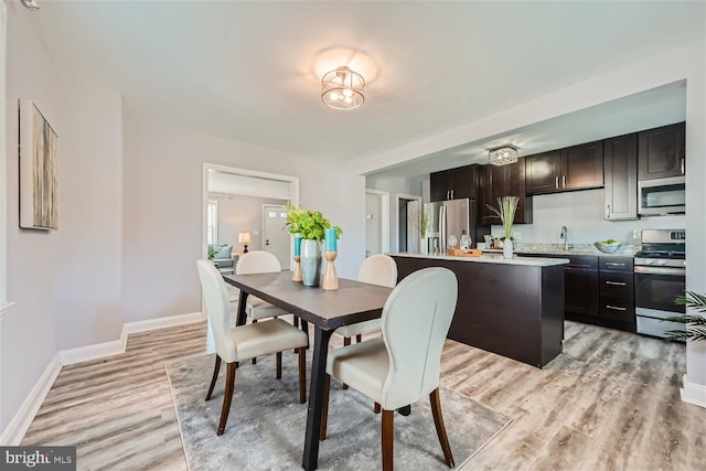 dining space with sink and light hardwood / wood-style floors