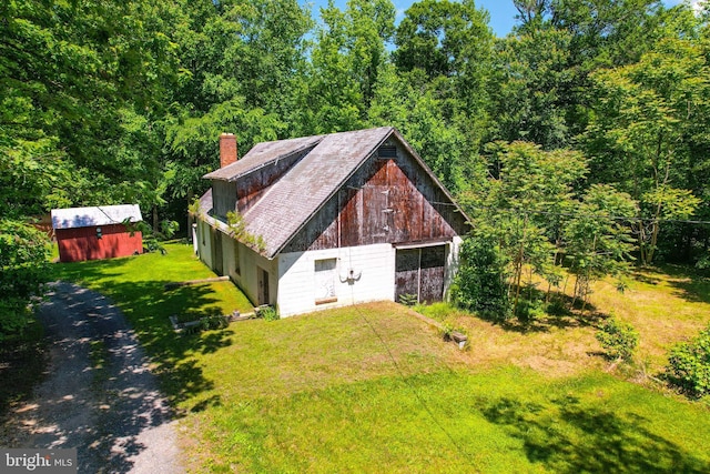 5709 Plummer Ln, Lothian, MD 20711 - view of side of home with a chimney, a yard, an outdoor structure, a barn, and a detached garage