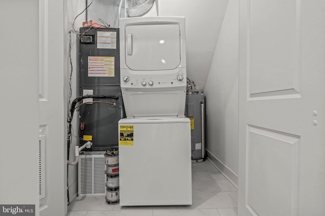 laundry room featuring stacked washer and dryer, electric water heater, and light tile floors