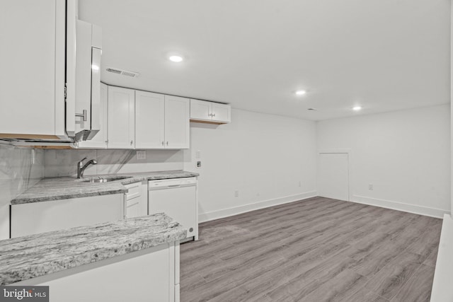 kitchen featuring light wood-type flooring, white cabinets, sink, tasteful backsplash, and dishwasher