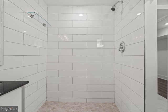 bathroom featuring a tile shower and hardwood / wood-style flooring