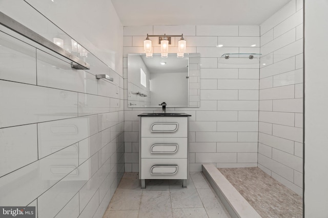 bathroom featuring tile flooring, sink, tile walls, and a shower