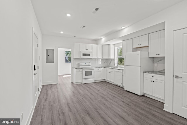 kitchen with sink, hardwood / wood-style flooring, white appliances, and tasteful backsplash