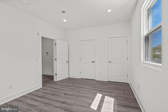 unfurnished bedroom with dark hardwood / wood-style flooring