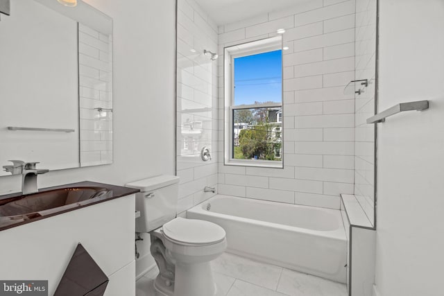 full bathroom with tile floors, tiled shower / bath, toilet, and vanity