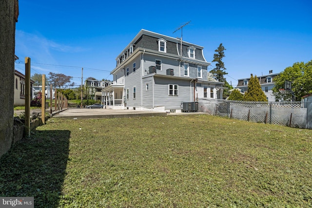 rear view of property featuring a patio area and a yard