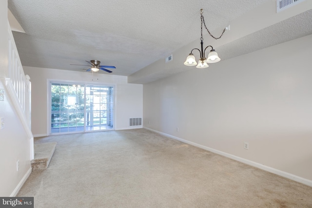 carpeted spare room with a textured ceiling and ceiling fan with notable chandelier