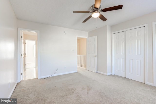 unfurnished bedroom featuring a closet, ceiling fan, and light colored carpet