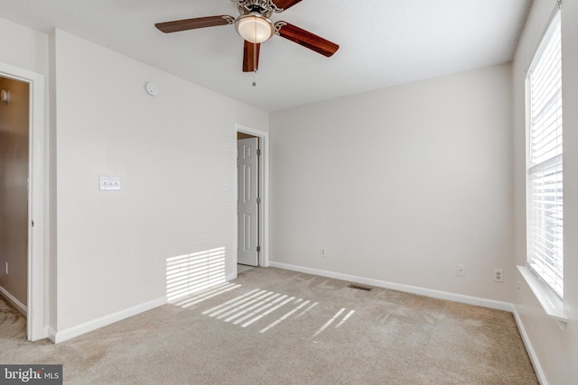 carpeted spare room with ceiling fan