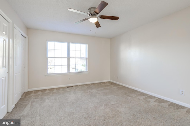 unfurnished bedroom with ceiling fan and light colored carpet