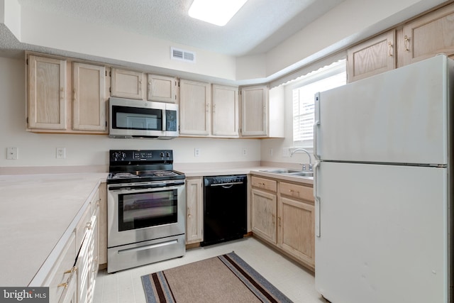 kitchen featuring light brown cabinets, a textured ceiling, stainless steel appliances, and sink