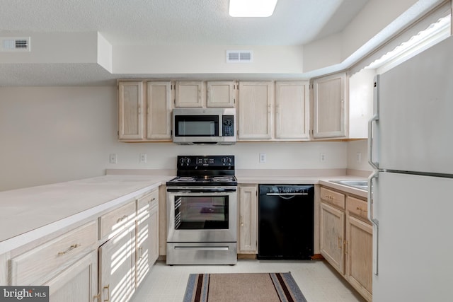 kitchen featuring a textured ceiling, light brown cabinets, and stainless steel appliances