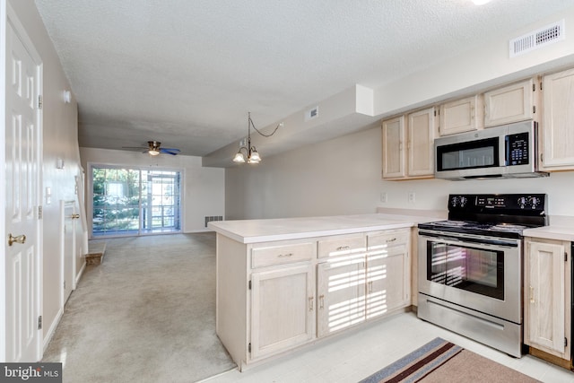 kitchen featuring appliances with stainless steel finishes, a textured ceiling, ceiling fan with notable chandelier, pendant lighting, and light colored carpet