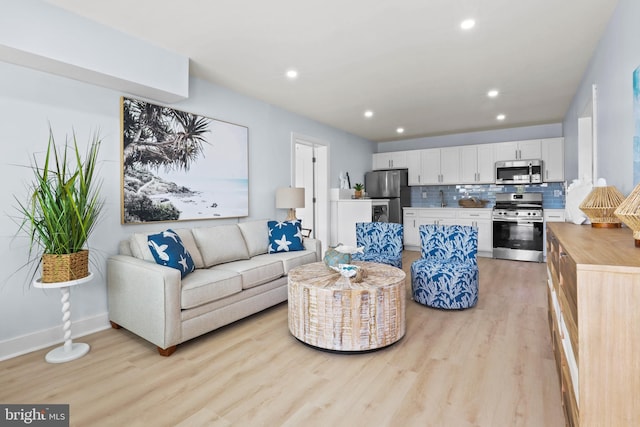 living room featuring light hardwood / wood-style floors and sink