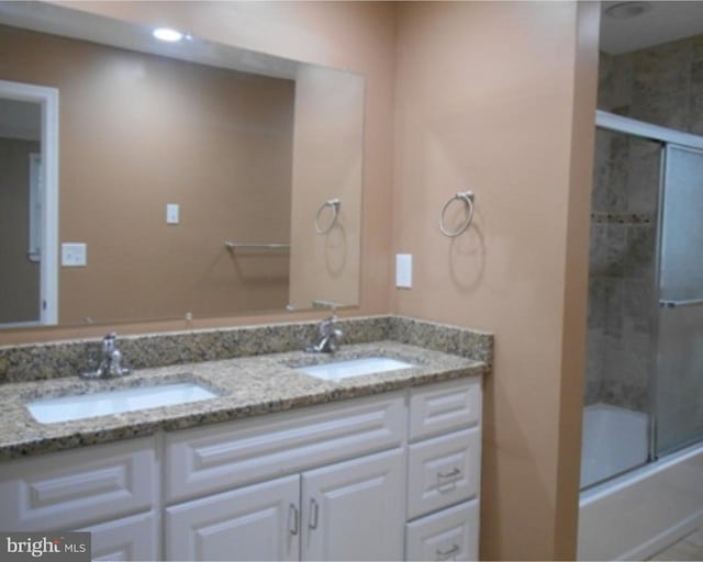 bathroom with dual vanity and enclosed tub / shower combo