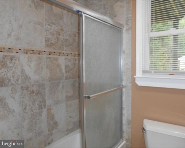 bathroom featuring a wealth of natural light and toilet