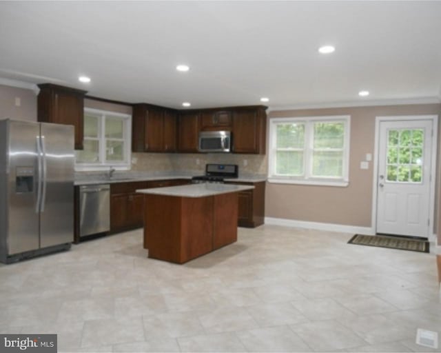 kitchen featuring stainless steel appliances, tasteful backsplash, light tile floors, and a kitchen island