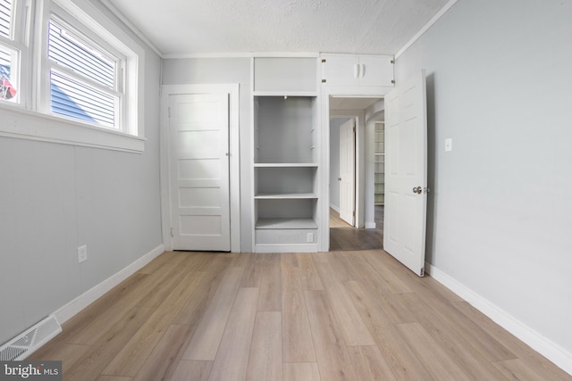 unfurnished bedroom with light wood-type flooring and crown molding