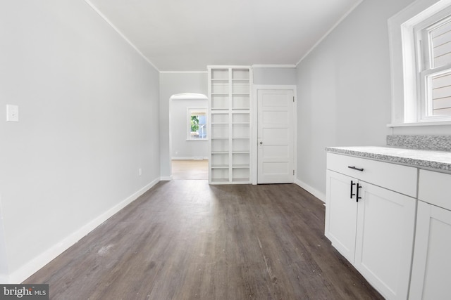 unfurnished living room featuring crown molding and dark hardwood / wood-style floors