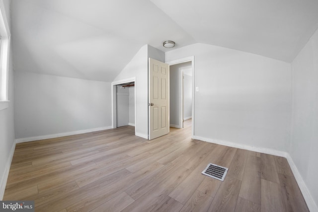 interior space featuring lofted ceiling, a closet, and light wood-type flooring