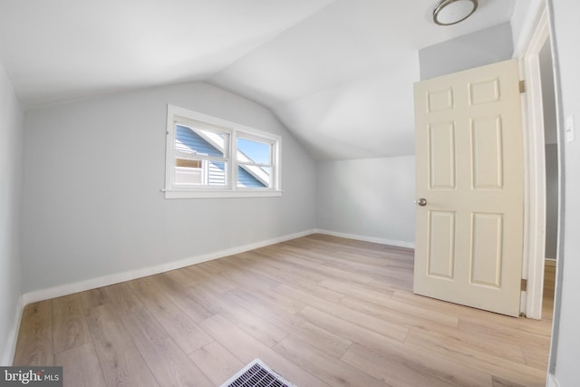 additional living space featuring light hardwood / wood-style flooring and lofted ceiling