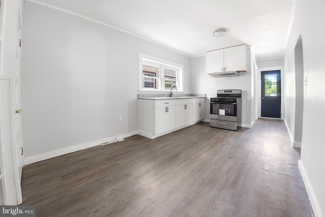 kitchen featuring white cabinets, hardwood / wood-style floors, stainless steel range oven, and ornamental molding