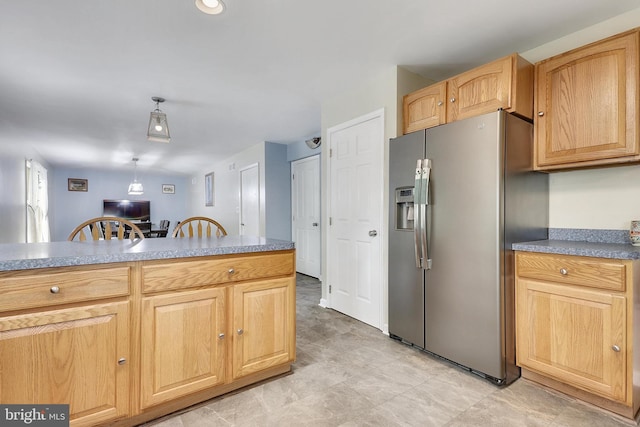 kitchen with stainless steel fridge, light brown cabinetry, and decorative light fixtures