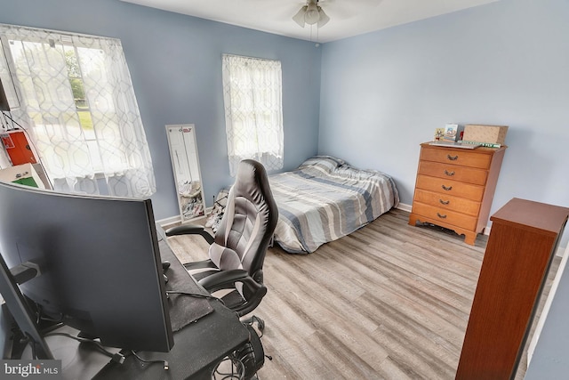 bedroom with multiple windows, ceiling fan, and light hardwood / wood-style floors