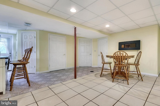 tiled dining area with a drop ceiling