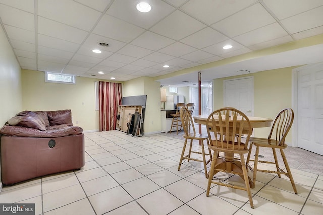 tiled dining area featuring a paneled ceiling