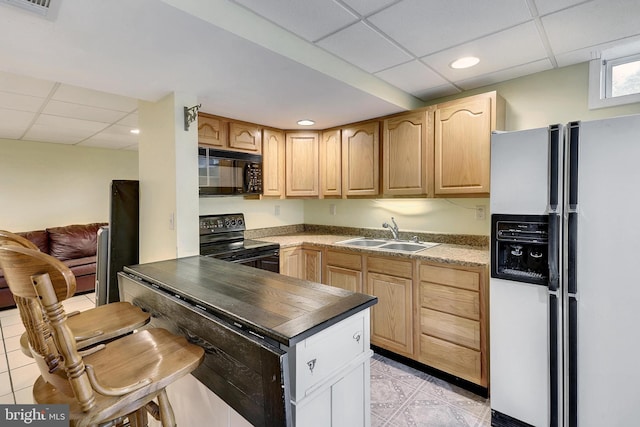 kitchen with light tile patterned floors, sink, a drop ceiling, and black appliances