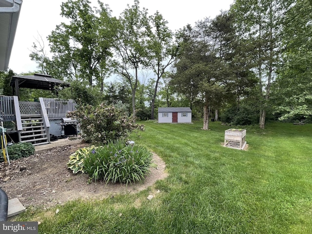 view of yard with a gazebo, a wooden deck, and an outdoor structure