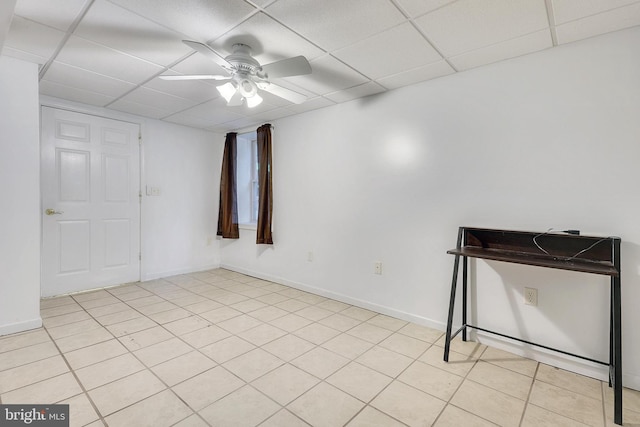 empty room featuring a drop ceiling, ceiling fan, and light tile patterned flooring