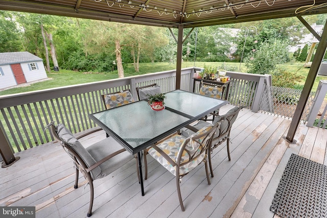 deck with a gazebo, a yard, and a shed