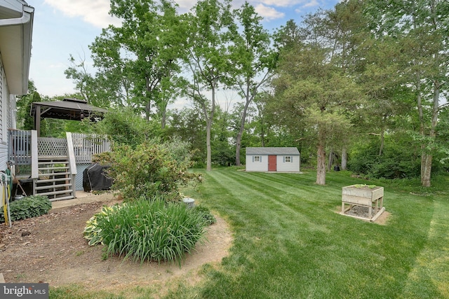 view of yard with a gazebo, a wooden deck, and a shed