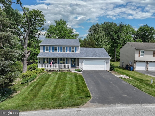 colonial-style house featuring a front lawn and covered porch