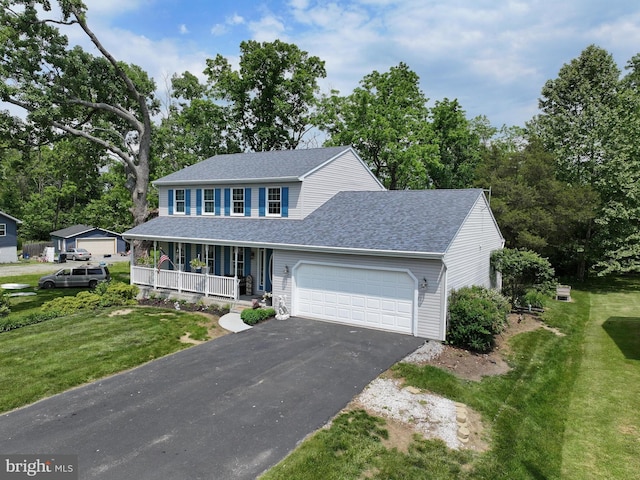 view of front facade with a porch, a garage, and a front lawn