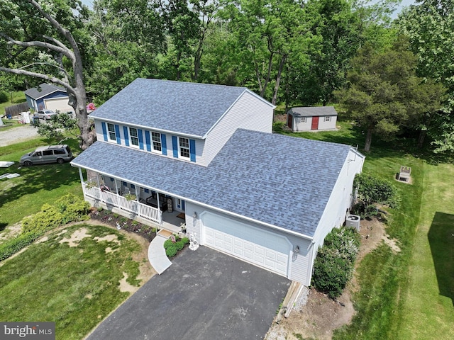 view of front of home with a porch, a garage, and a front yard