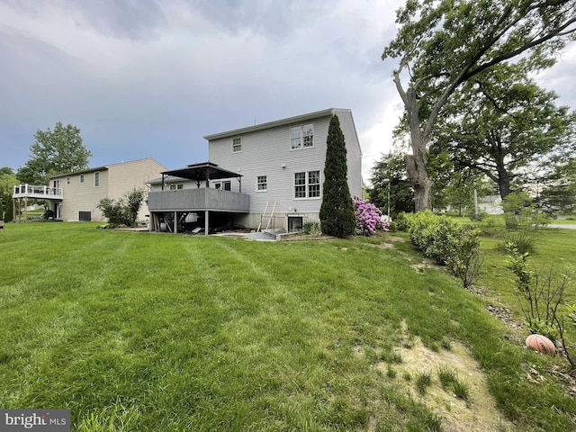 back of property with a lawn and a deck