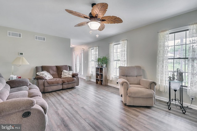 living room with ceiling fan, light wood-type flooring, and a wealth of natural light