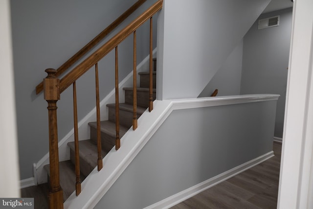 stairway with dark hardwood / wood-style floors