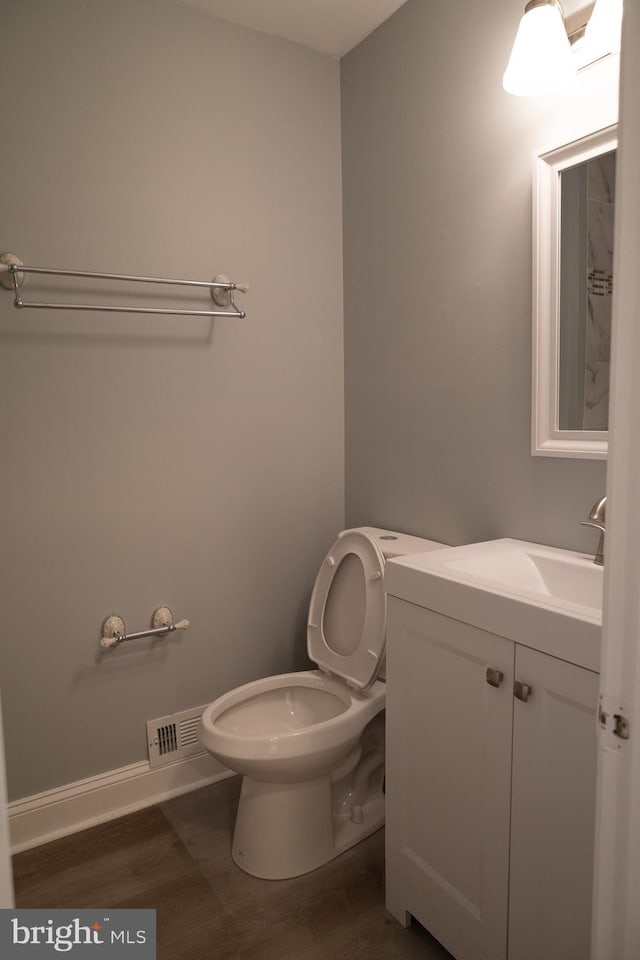 bathroom featuring hardwood / wood-style floors, vanity, and toilet