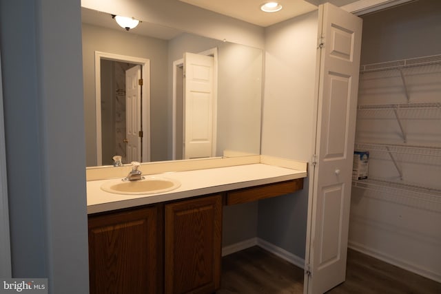 bathroom with large vanity and wood-type flooring