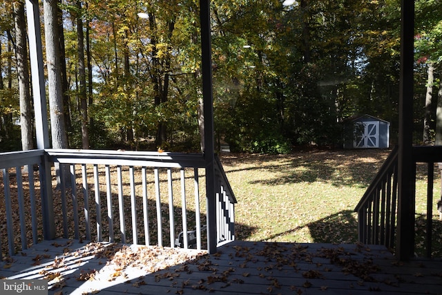 deck featuring a storage shed and a lawn